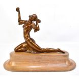 An Art Deco bronzed metal figure of a kneeling girl with out swept arm supporting a ball raised on