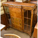 An early 20th century burr walnut veneered side by side bureau bookcase, the central section with