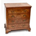 A reproduction burr walnut veneered chest with brush slide above four drawers on ogee bracket