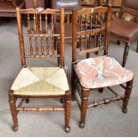 A harlequin set of seven spindle back and rush seated dining chairs raised on column supports (7).