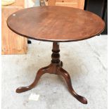 A George III mahogany tilt top tripod table with birdcage action, raised on three out-swept