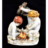 MEISSEN; an early 20th century figure group modelled as three nude boys beside a fire, blue