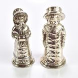A pair of Britannia metal novelty pepperettes modelled in the form of children, height of largest