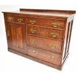 A late 19th century oak sideboard with two short drawers above cupboard door flanked by four long
