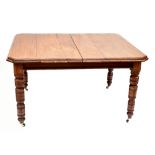 A Victorian walnut extending dining table with two additional leaves raised on ring turned legs to