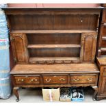 A Georgian style oak dresser, the plate rack back with two panelled doors and six spice drawers, the