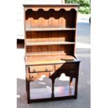 A reproduction oak dresser with plate rack back of small proportions, the back with two fixed
