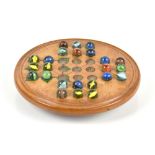 A late 19th century turned fruit wood solitaire board for marbles with compartment to lower