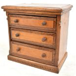 A late 19th/early 20th century oak apprentice chest of three drawers with inlaid checkered base,