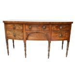 A Georgian mahogany bow front sideboard with an arrangement four drawers, raised on bamboo form