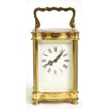 A late 19th century brass cased carriage clock, the dial with Roman numerals, height including swing