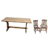 A reproduction oak dining suite comprising refectory table raised on lyre supports, height 73cm,