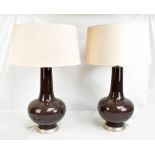 PORTA ROMANA; a pair of brown glazed ceramic bottle form table lamps on silvered circular bases,