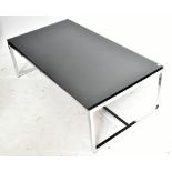 A contemporary chrome framed coffee table with black glass top, raised on block supports, height