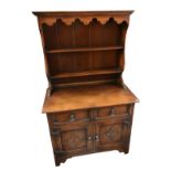 A reproduction oak Priory style dresser with plate rack back above two drawers and two panelled