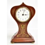 An Edwardian brass inlaid timepiece of balloon form inlaid with floral detail raised on brass clad