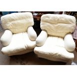 IN THE MANNER OF HOWARD & SONS; a pair of upholstered arm chairs with low backs, swept arms and