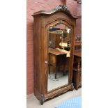 An early 20th century French armoire, with carved detail to the cornice and shoulders above a