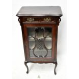 A late Victorian stained mahogany music cabinet with single drawer above single glazed door,