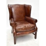 A reproduction studded leather upholstered wing back arm chair on stretchered square section