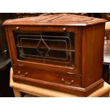 A reproduction cherry wood corner TV stand with inlaid brass detail, pull down glazed door and a
