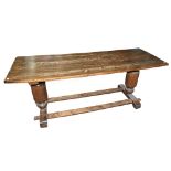 A 20th century oak and elm refectory dining table, raised on cylindrical supports, height 76,