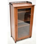 An Edwardian mahogany music cabinet with pierced gallery back above single glazed door enclosing