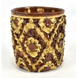 A slipware beaker of cylindrical form with thick external moulded stylised floral decoration and