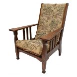 An Arts & Crafts oak framed reclining chair with embroidered upholstery.