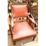 A late 19th/early 20th century walnut framed leather upholstered armchair with carved detail on