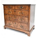 A George III walnut straight front chest of two short over three long drawers, raised on bracket