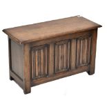 A reproduction oak Priory style coffer with linen fold decoration, height 51.5cm, length 86cm, depth