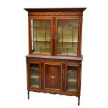 An Edwardian mahogany and inlaid display cabinet, the upper section with twin glazed doors enclosing