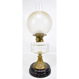 A 19th century oil lamp with foliate etched globular shade and chimney on clear glass reservoir to