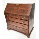 A Georgian oak bureau, the fall-front enclosing a fitted interior with green leather slope, above