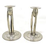 ARCHIBALD KNOX FOR TUDRIC PEWTER AND LIBERTY & CO; a pair of Arts and Crafts candlesticks, the