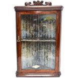 A late 19th/early 20th century stained pine hanging flat fronted corner cabinet, with carved cornice