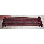 A red ground runner with geometric detail, approx 220 x 56cm.Additional InformationSome light