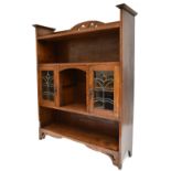 An Arts & Crafts medium oak freestanding bookcase with two leaded glazed doors above single shelf,