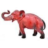CHARLES NOKE FOR ROYAL DOULTON; a flambé glazed elephant, signed with printed mark to feet, length