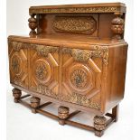 An early 20th century carved oak sideboard, the back with central carved panel flanked by carved