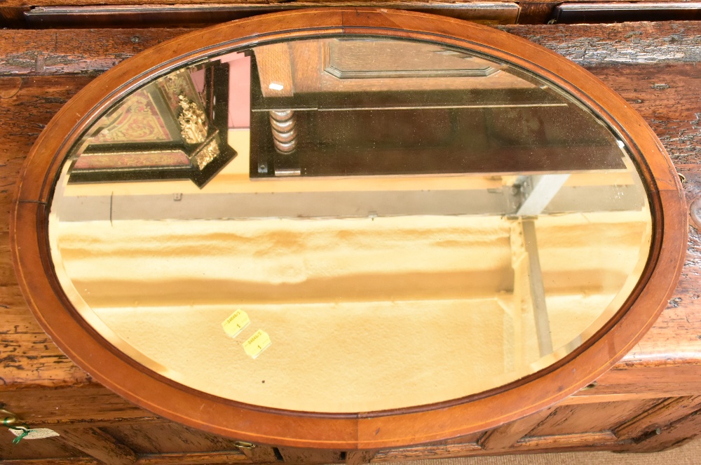 An Edwardian mahogany and line inlaid oval wall mirror with bevelled plate, 69 x 49cm.Additional