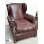 A late 19th/early 20th century leather upholstered wing back armchair for restoration, on front