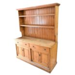 A late 19th/early 20th century pine and pitch pine dresser with boarded plate rack and base of two