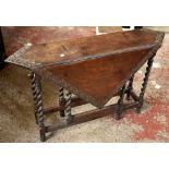 An oak gate leg table with carved foliate detail on barley twist supports, 71 x 114 x 110cm when