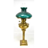 An early 20th century brass Corinthian column oil lamp with green glass shade, overall height 72cm.