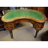 A 19th century mahogany kidney-shaped writing desk with brass gallery and gilt tooled green