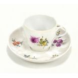 A late 19th century German porcelain cup and saucer decorated with floral sprays and with pseudo