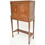 An Edwardian Arts & Crafts mahogany, burr walnut and further inlaid cabinet, the upper section