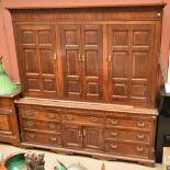 An 18th century oak housekeeper's cupboard, the upper section with four panelled doors enclosing